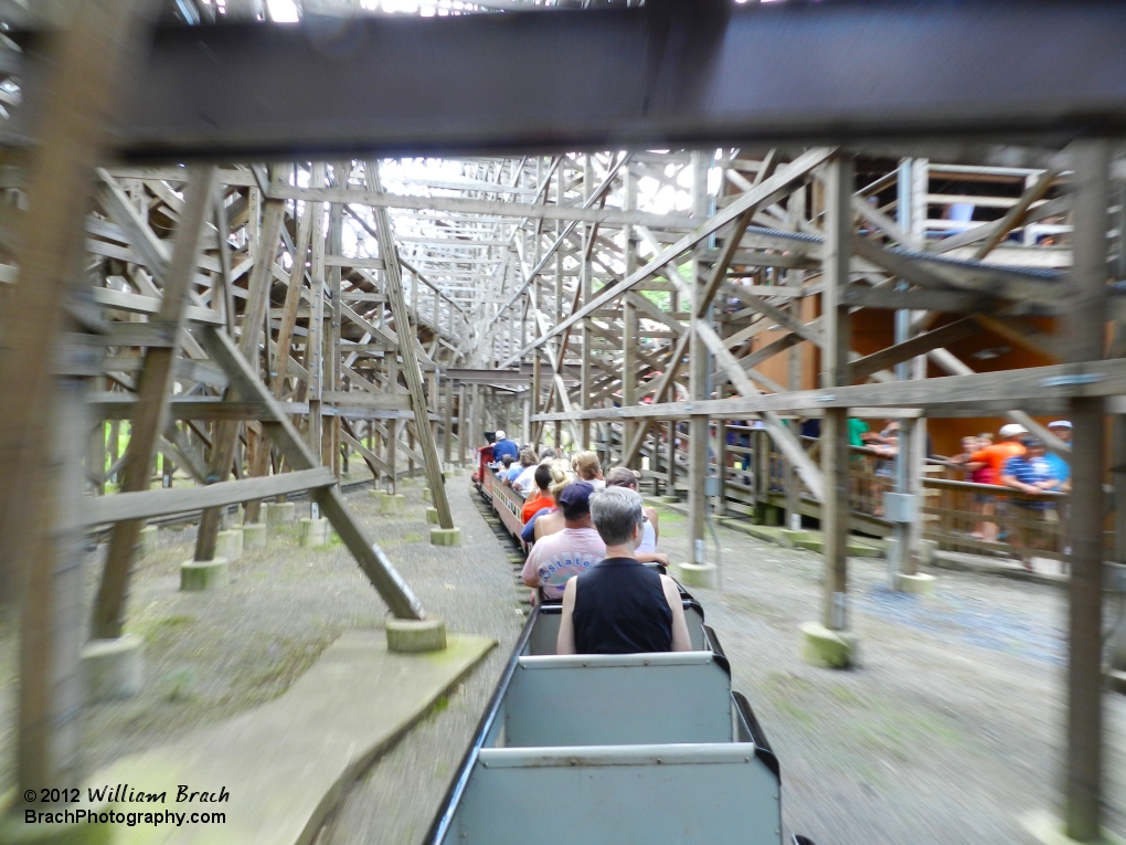 Red train traveling under Twister's structure.